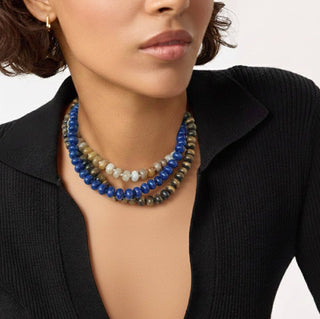 Layered beaded necklaces with blue, cream, and brown strands and gold-toned clasp