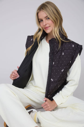 Black puffer vest with high neck, front zipper, and small light print pattern