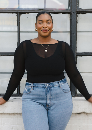 Elietian Seamless Sheer Mesh Top in Black over a black tank with light jeans, curvy model
