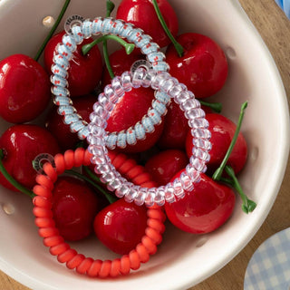 TELETIES hair tie set arranged in a bowl: red and clear light-blue gingham spirals