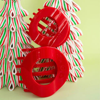 Pair of large red flat circle hair clips with ridged grips