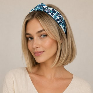 Woman wearing navy floral woven headband with embroidered blossoms across her head