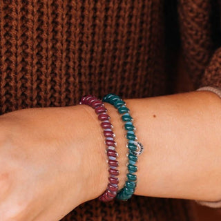 Teleties small spiral hair ties in Harvest Hues teal, berry plaid and burgundy, worn on the wrist