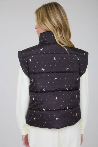 Back view of black polka-dot bow print puffer vest with padded quilt lines