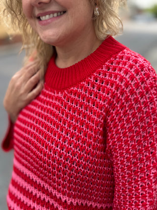 Red knit sweater with white horizontal stripes and ribbed crew neckline