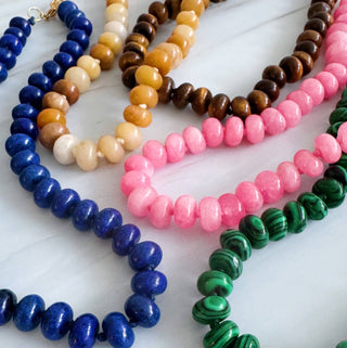 Layered round bead necklaces in blue, cream, tan, brown, pink, and green