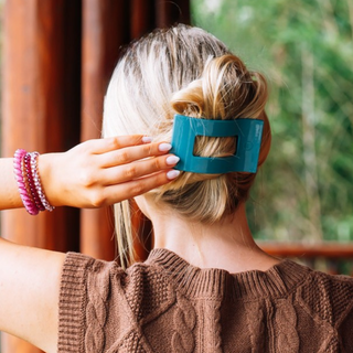 TELETIES teal flat rectangle hair clip holding blonde hair in place