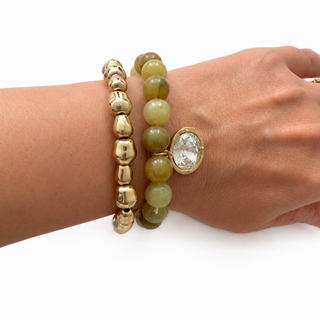 Olive marbled bead stretch bracelet with gold beads and round crystal charm on wrist