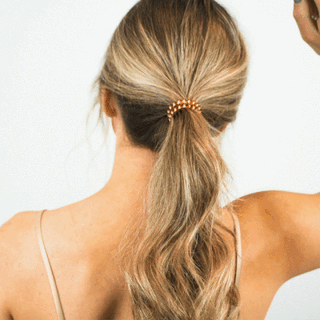 TELETIES rose-pink large coiled hair tie holding ponytail at back