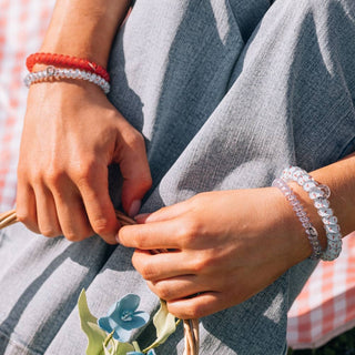 TELETIES wrist and arm wearing clear light-blue gingham and red coiled hair ties