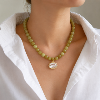 Olive beaded crystal pendant necklace on neckline with gold-tone round pendant