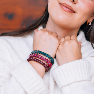 Teleties large spiral hair ties in Harvest Hues teal, berry plaid and burgundy, worn on the wrist