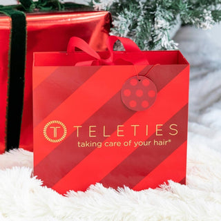 Red TELETIES gift bag advent calendar with ribbon handles on white faux-fur