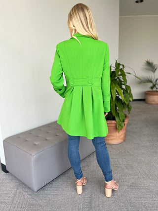 Green long-sleeve coat with button front and hip pockets, back view.