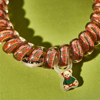 TELETIES festive plaid hair ties with small teddy bear charms, arranged in a circle