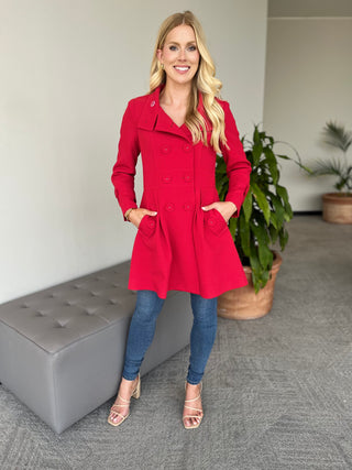 Red long-sleeve coat with button front and flared skirt, front view.