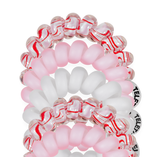 TELETIES close-up of tiny spiral hair ties in pink and white with red striped bands