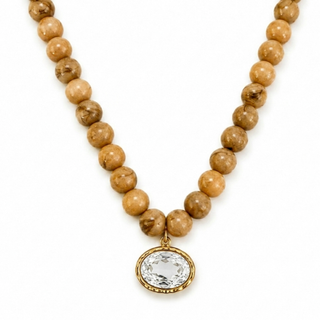Tan marbled bead necklace with oval crystal pendant in gold-tone frame