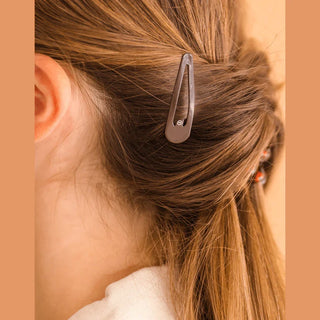TELETIES Brown snap clip holding hair at the side