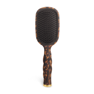 Detangling hair brush with dark cushion and tortoise-pattern handle, angled view