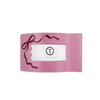 Pink flat rectangle hair clip with bow cutout and TELETIES logo