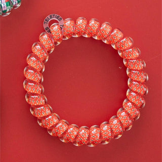 TELETIES orange patterned coiled hair tie arranged in a circle