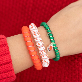 TELETIES beaded hair ties on wrist: orange, white with red stripes, and green spiral bands