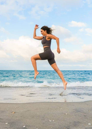 High waist bike shorts in dark color, side view of fitted mid-thigh length