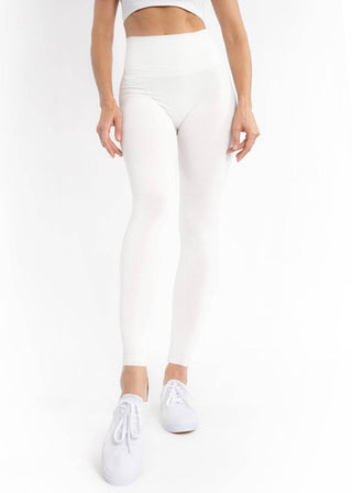 Ivory high-waisted leggings, full length, fitted stretch fabric.