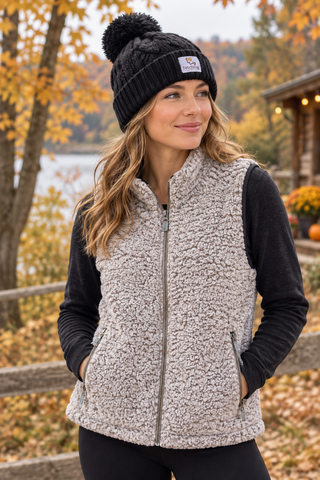 Woman wearing the Fetching Sherpa Vest over a black top with a knit beanie