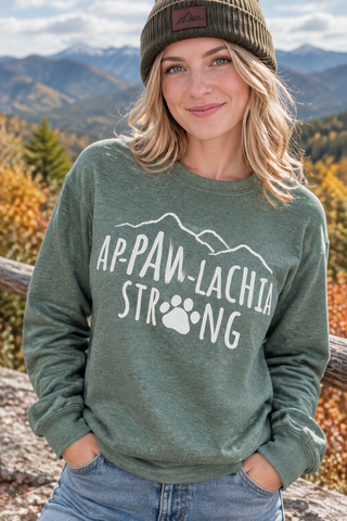 Woman wearing the green Ap-paw-lachia Strong Sweatshirt outdoors