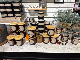 Assorted soy candles in jars and tins on store display, Woodland Snow labels
