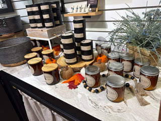 Assorted soy candles in tins and jars with Woodland Snow labels on display