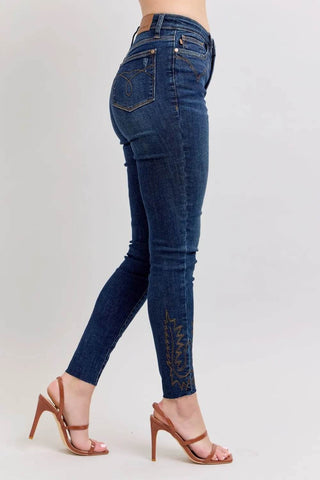 Angled side view of Plus Size High Rise Embroidered Skinny Jeans highlighting curve-enhancing design and stylish ankle embroidery.