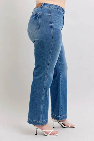 Side view of Judy Blue Full Size High Waist Straight Jeans on plus size model, emphasizing comfort stretch and classic blue tone.