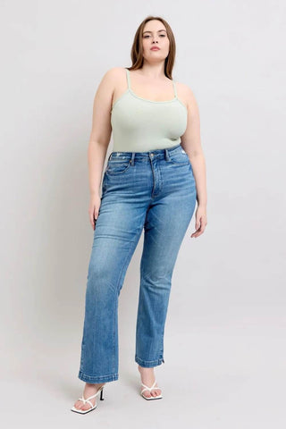 Full body view of plus-size model wearing Judy Blue Tummy Control Boot Jeans styled with a mint green tank top.
