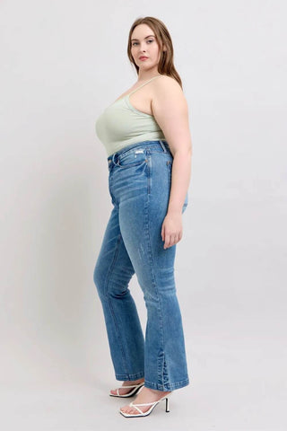 Side profile of plus-size model in Judy Blue HW Tummy Control Boot Jeans with vintage wash and flattering silhouette.