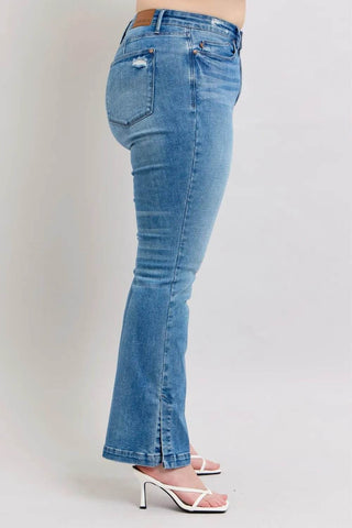 Profile view of Judy Blue Vintage Wash Boot Jeans on plus-size model showing flattering fit and trendy slit hem.