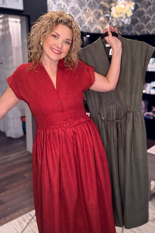 Model wearing the Wine Carole Christian pinwale corduroy belted midi dress, holding the Olive color
