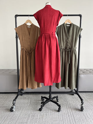 Pinwale corduroy belted midi dresses on a clothing rack, including Wine and Olive, front view