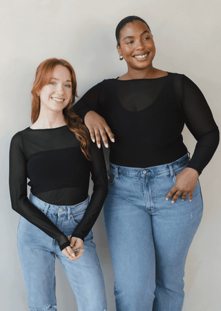 Black sheer long sleeve top paired with blue jeans, scoop neckline