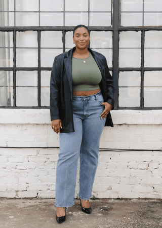 Women’s olive green waist-length top with crew neck, worn under black jacket