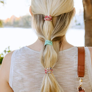 Small Spring Splash spiral hair ties holding a blonde ponytail, mint and multicolor striped